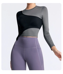 Détail du haut de yoga bicolore avec logo TEETKE et tissu extensible respirant