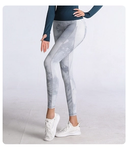 Vista dettagliata dei leggings da yoga tie-dye a vita alta su una modella in studio