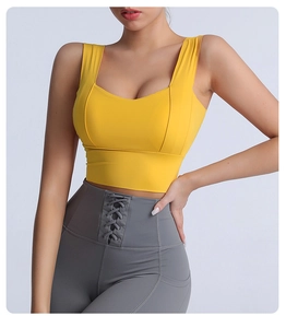 Detail view of high-waist grey leggings with unique cross-tie design and yellow sports bra