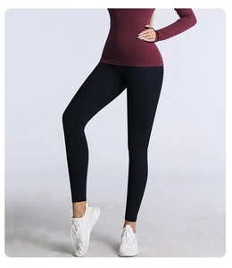 Vue complète d'un legging de yoga noir taille haute porté avec des baskets blanches sport