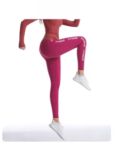 Détail du legging de sport taille haute magenta avec imprimé Fitness blanc sur la jambe