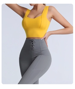 Detail of high-waist yoga leggings with side pockets and criss-cross waist ties