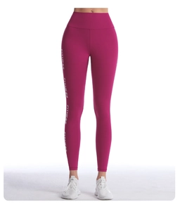 Détail du legging de sport magenta à taille haute avec imprimé FITNESS vertical blanc