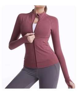 Detailed close-up of pink slim-fit yoga zip-up top with high collar and thumbholes