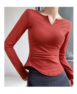 Detail of ruched waist design on a brick red slim fit V-neck long sleeve yoga top
