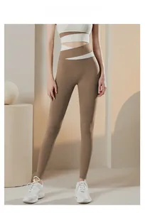 Dettaglio dei leggings da yoga a vita alta con fascia incrociata marrone e bianca