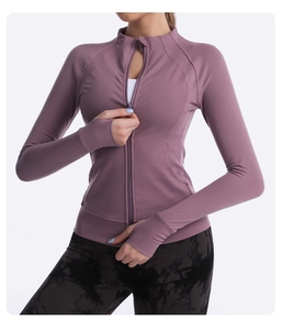 Detail of slim-fit yoga jacket showing stand collar, zipper, and thumbhole cuffs in pink