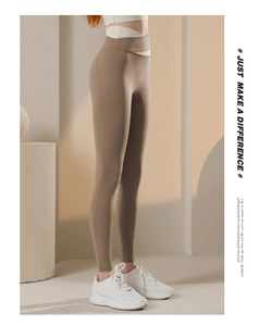 Dettaglio dei leggings yoga a vita alta con incrocio bianco in vita ed effetto modellante