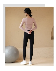 Détail du haut de sport rose à manches longues et du legging de yoga noir taille haute