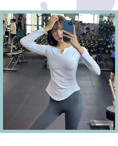 Close-up of white V-neck yoga top with side pleats and grey high-waist fitness leggings