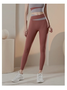 Dettaglio dei pantaloni da yoga bicolore a vita alta con design incrociato in vita