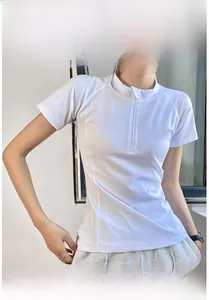 Detail of white women's athletic top featuring stand collar and quarter-zip closure