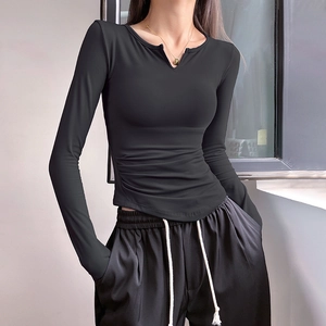Women's black V-neck long sleeve yoga top with ruching details and thumb holes