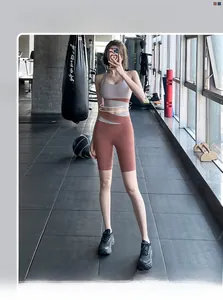 Close-up of high-waist patchwork sports shorts and matching bra in grey and red