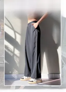 Detail of high waist joggers featuring adjustable zipper and drawstring cuffs at the hem