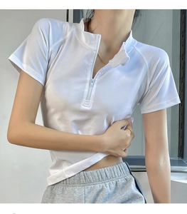 Detail of white women's athletic quarter-zip top with stand collar and raglan sleeves
