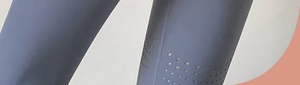 Detail showing breathable laser-cut holes on high-waisted dark grey blue yoga pants