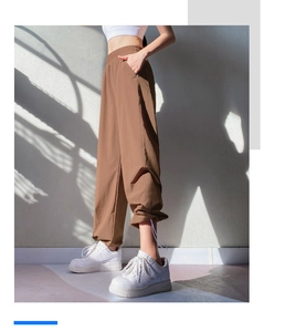 Detail view of brown high-waisted jogger pants with adjustable drawstring hem cuffs