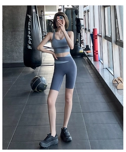 Close-up of high-waist biker shorts and racerback sports bra in blue color block design