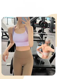 Détail des bretelles croisées du soutien-gorge de sport lilas et du legging de yoga marron