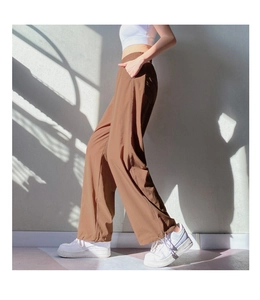 Detail of high-waisted brown joggers featuring elastic waistband and functional side pockets
