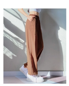 Detail view of brown high-waisted sports pants featuring elastic waist and side stitching