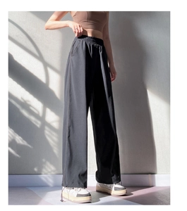 Detailed view of high-waist joggers with adjustable drawstring cuffs and hidden zip pockets