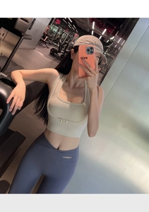 Λεπτομερής selfie σε καθρέφτη με μπεζ αθλητικό σουτιέν και μπλε κολάν στο γυμναστήριο