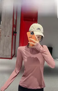 Détail du haut de sport rose ajusté avec demi-zip et tissu respirant extensible