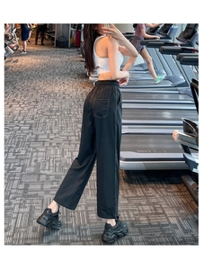 Detail of high-waisted black sports trousers with loose fit and quick-dry fabric