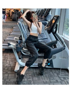 Detail of high-waisted black joggers featuring contrast stitching and drawstring waist