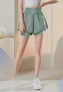 Detail of high-waisted sage green two-in-one sports shorts with elastic pleated waistband