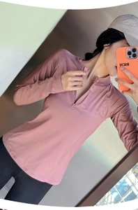 Détail du haut de sport rose poudré avec demi-fermeture éclair et tissu respirant ajusté