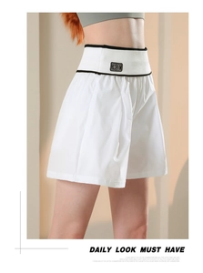 Dettaglio di pantaloncini sportivi bianchi a vita alta con cintura a contrasto e ricamo BK