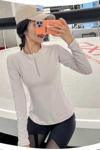 Détail du haut de fitness gris clair à demi-zip avec col montant et coupe ajustée