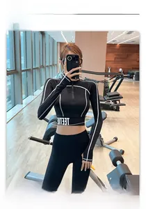 Détail du haut de yoga noir à demi-zip avec coutures contrastées et passe-pouces
