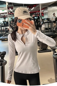 Détail du haut de sport cintré à manches longues avec demi-zip et découpe goutte