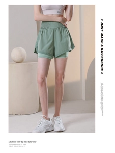 Detail of high waisted light green 2-in-1 sports shorts with elastic pleated waistband