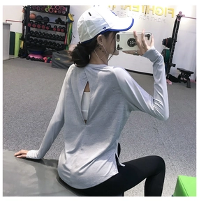 Détail de la fente au dos et de la texture géométrique du haut de sport gris à manches longues