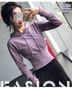 Détail du sweat à capuche court violet avec taille côtelée et pantalon de yoga noir