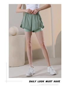 Detail view of double-layered sage green running shorts with wide elastic waistband
