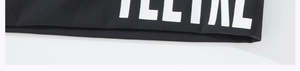 Détail du bord du tissu noir d'un t-shirt de yoga avec couture de qualité et logo blanc