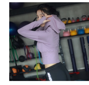 Détail du haut de sport violet à manches longues avec passe-pouces en salle de gym