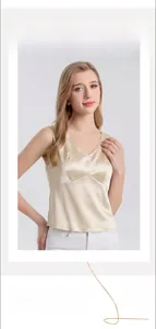 Detailed close-up of champagne silk V-neck camisole showing glossy satin texture