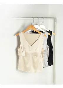 Detailed view of silk V-neck camisoles showing smooth texture in apricot, grey and black