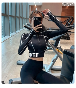 Détail d'un ensemble de yoga noir avec haut à demi-zip et coutures contrastées sport