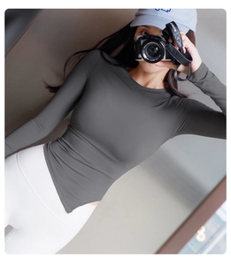 Détail du haut de sport à manches longues gris foncé avec ourlet asymétrique