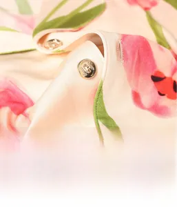Gros plan d'un pyjama en soie avec boutons dorés et motifs tulipes roses