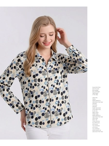 Detailed view of women's silk blouse featuring blue polka dots and front zipper closure