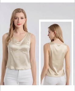 Detail view of champagne silk V-neck tank top showing smooth texture and elegant fit